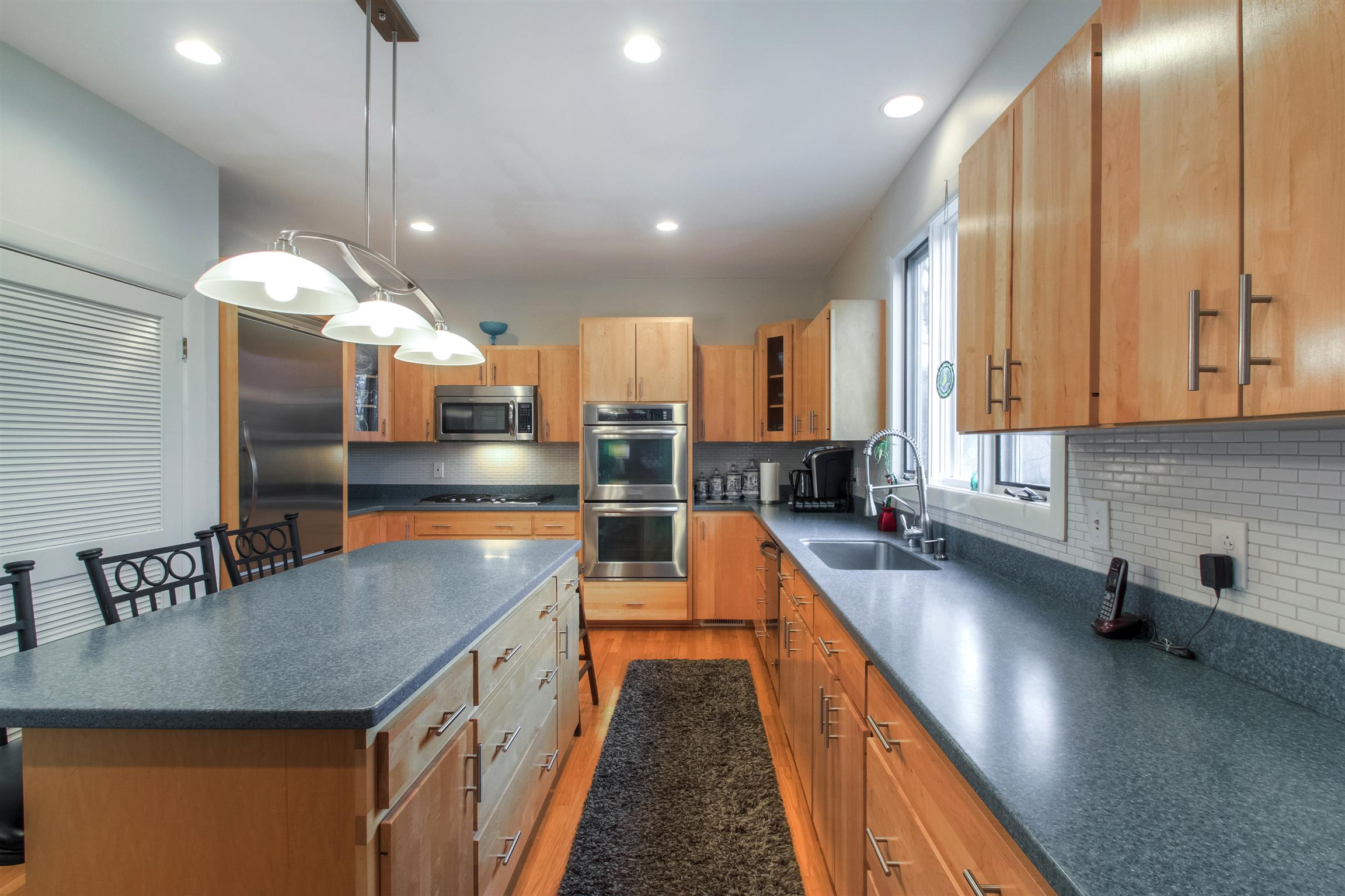 788 High Point Ridge Road Franklin, TN 37069 - Photo 20 of 30 a kitchen with stainless steel appliances granite countertop a sink a stove and a wooden floors