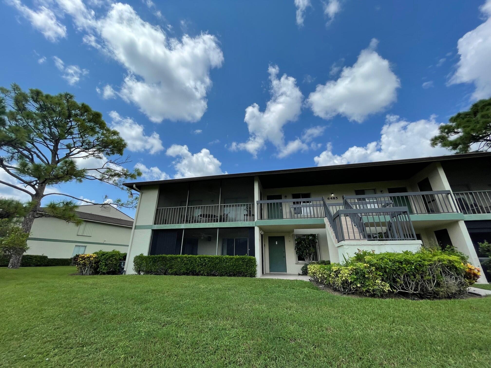 6485 Chasewood Drive, Unit C Jupiter, FL 33458 - Photo 1 of 23 a front view of a house with a yard