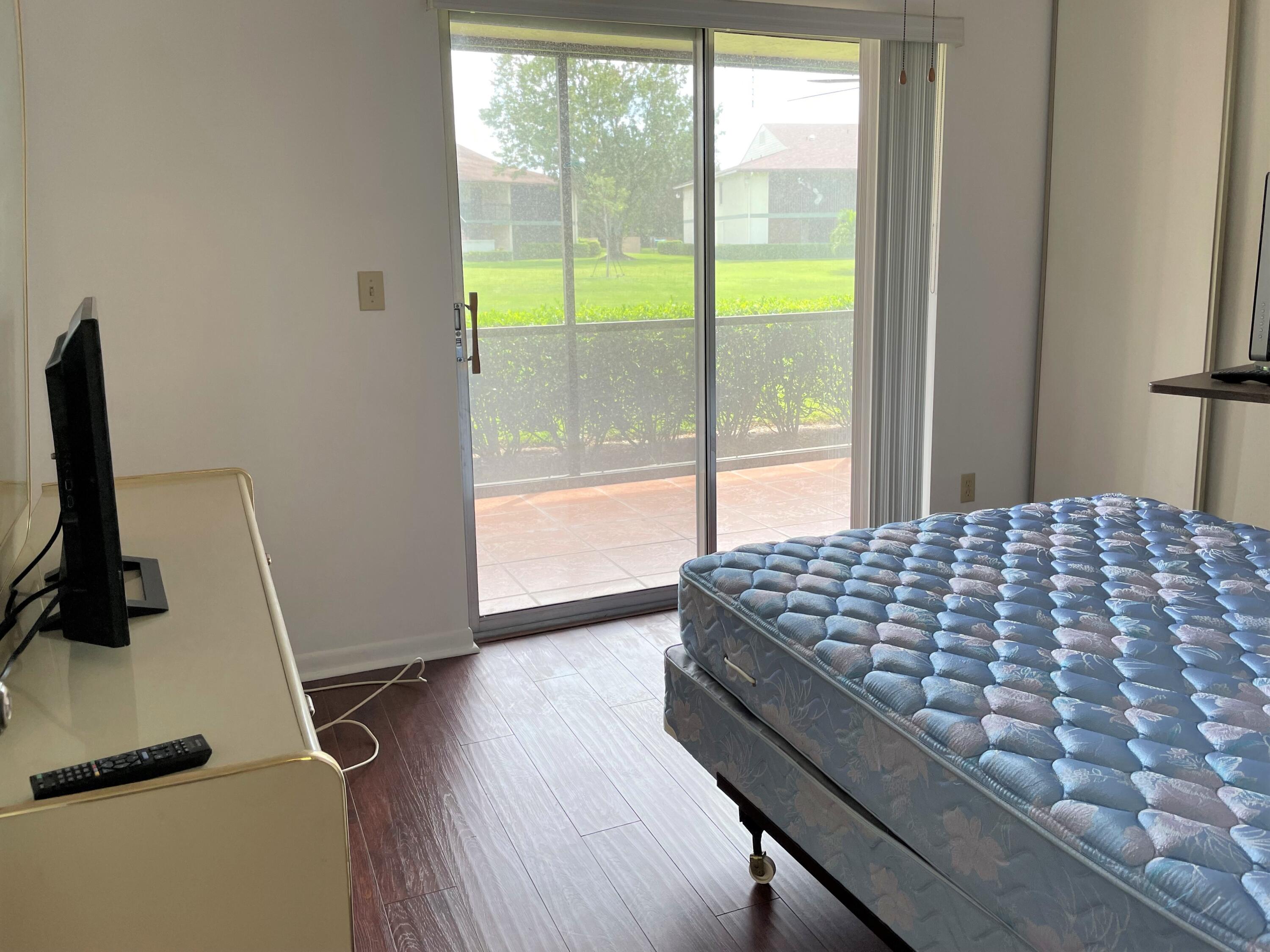 6485 Chasewood Drive, Unit C Jupiter, FL 33458 - Photo 13 of 23 a bedroom with a bed and a window