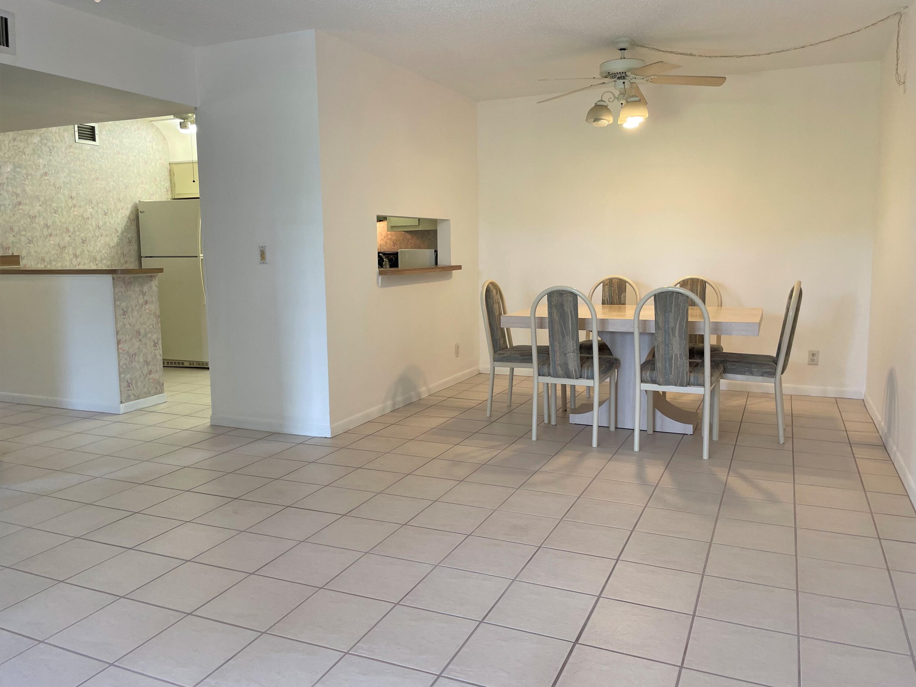 6485 Chasewood Drive, Unit C Jupiter, FL 33458 - Photo 3 of 23 a dining room with furniture and a chandelier
