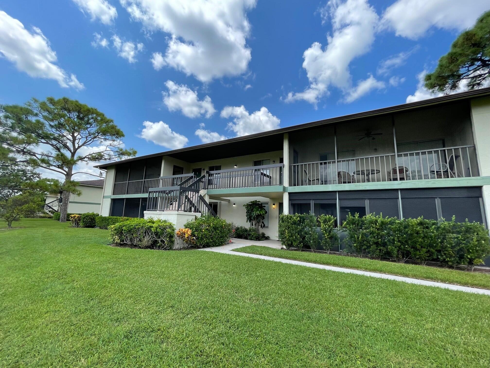 6485 Chasewood Drive, Unit C Jupiter, FL 33458 - Photo 21 of 23 a front view of house with yard and green space