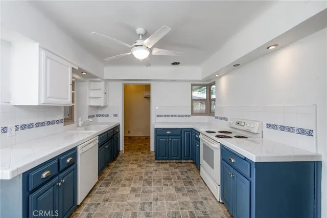 a kitchen with a stove a sink a refrigerator and cabinets