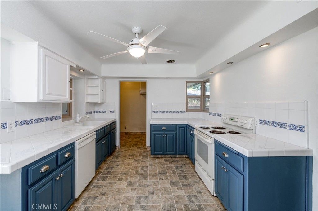 610 Park Madera, CA 93637 - Photo 14 of 35 a kitchen with a stove a sink a refrigerator and cabinets