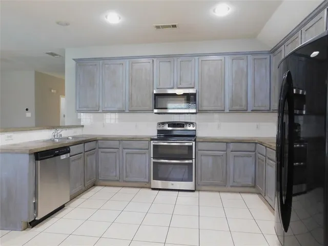 a kitchen with a sink a stove and refrigerator