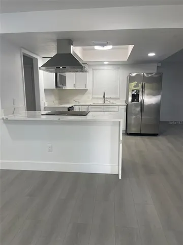 a large kitchen with stainless steel appliances a sink and a refrigerator