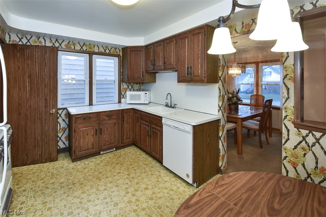 4026 Stonehaven Road Cleveland, OH 44121 - Photo 3 of 30 Kitchen featuring light tile floors, sink, white appliances, a notable chandelier, and decorative light fixtures