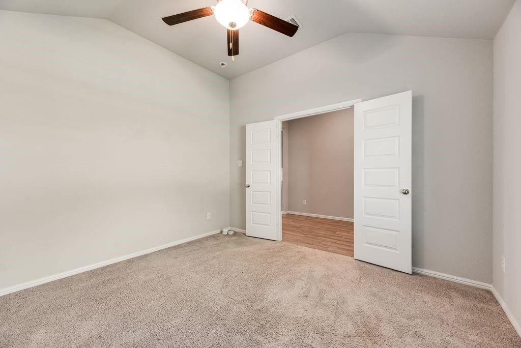 14216 Aberavon Drive Pilot Point, TX 76258 - Photo 6 of 19 Vaulted ceiling room with ceiling fan, neutral wall paint, and carpet flooring