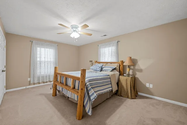 a bedroom with a large bed and a chandelier