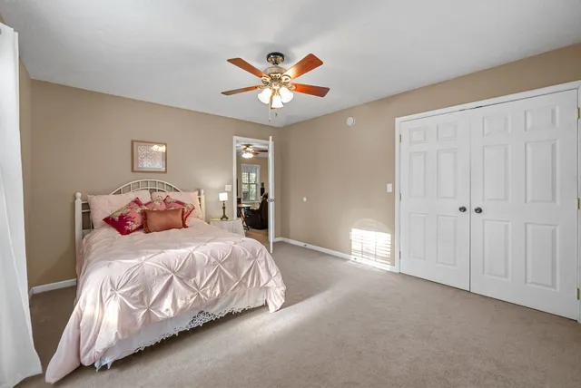 a bedroom with a large bed chandelier and a window