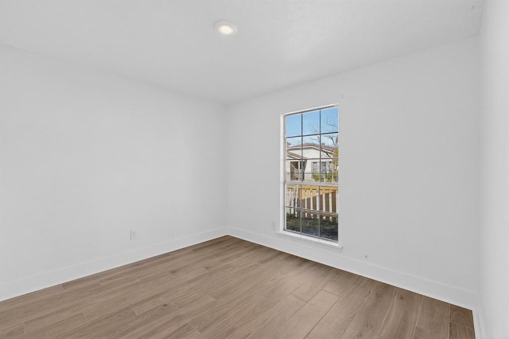 9918 Cedar Mountain Circle Dallas, TX 75217 - Photo 16 of 23 an empty room with wooden floor and windows