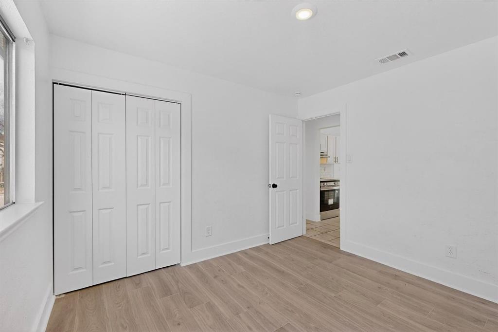 9918 Cedar Mountain Circle Dallas, TX 75217 - Photo 18 of 23 a view of an empty room with closet and wooden floor