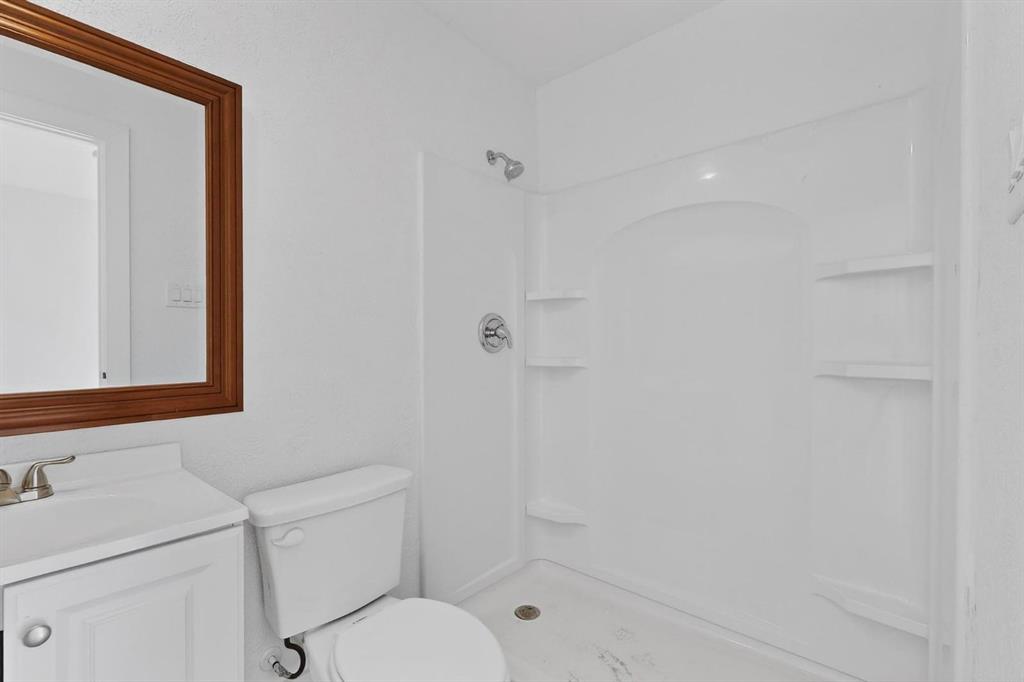 9918 Cedar Mountain Circle Dallas, TX 75217 - Photo 19 of 23 a bathroom with a toilet sink vanity and shower