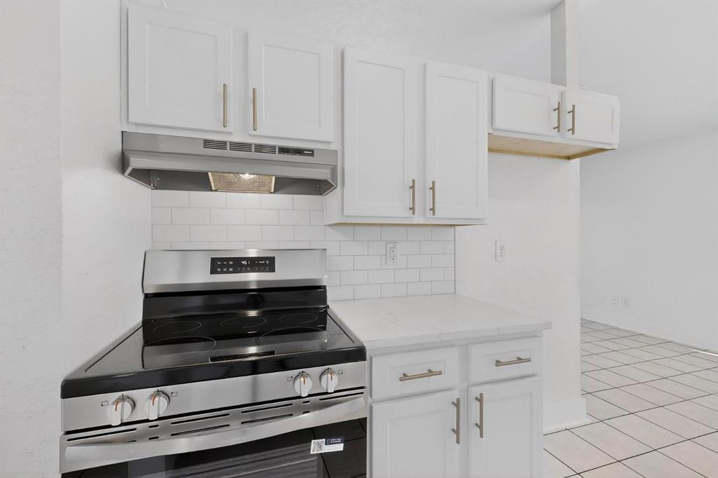 9918 Cedar Mountain Circle Dallas, TX 75217 - Photo 9 of 23 a kitchen with white cabinets and appliances