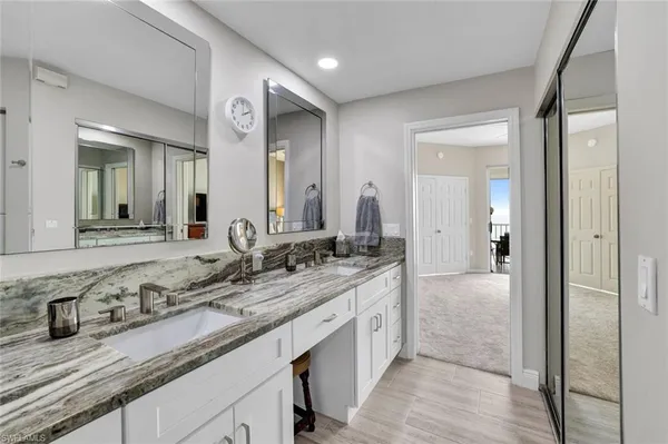 a spacious bathroom with a granite countertop sink and a mirror