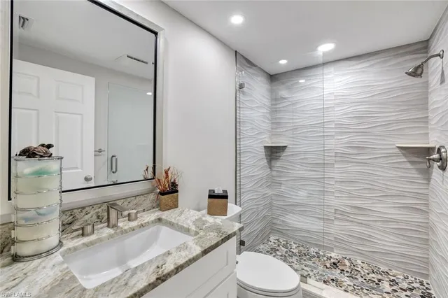 a bathroom with a granite countertop sink toilet and shower