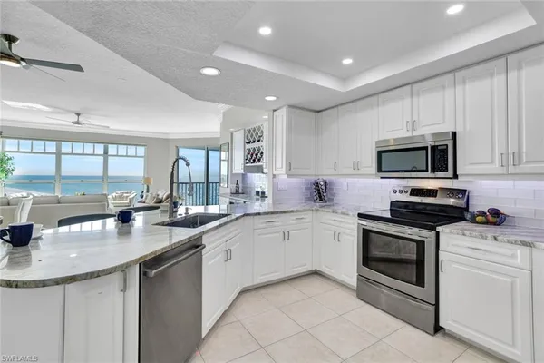 a kitchen with sink a microwave and cabinets