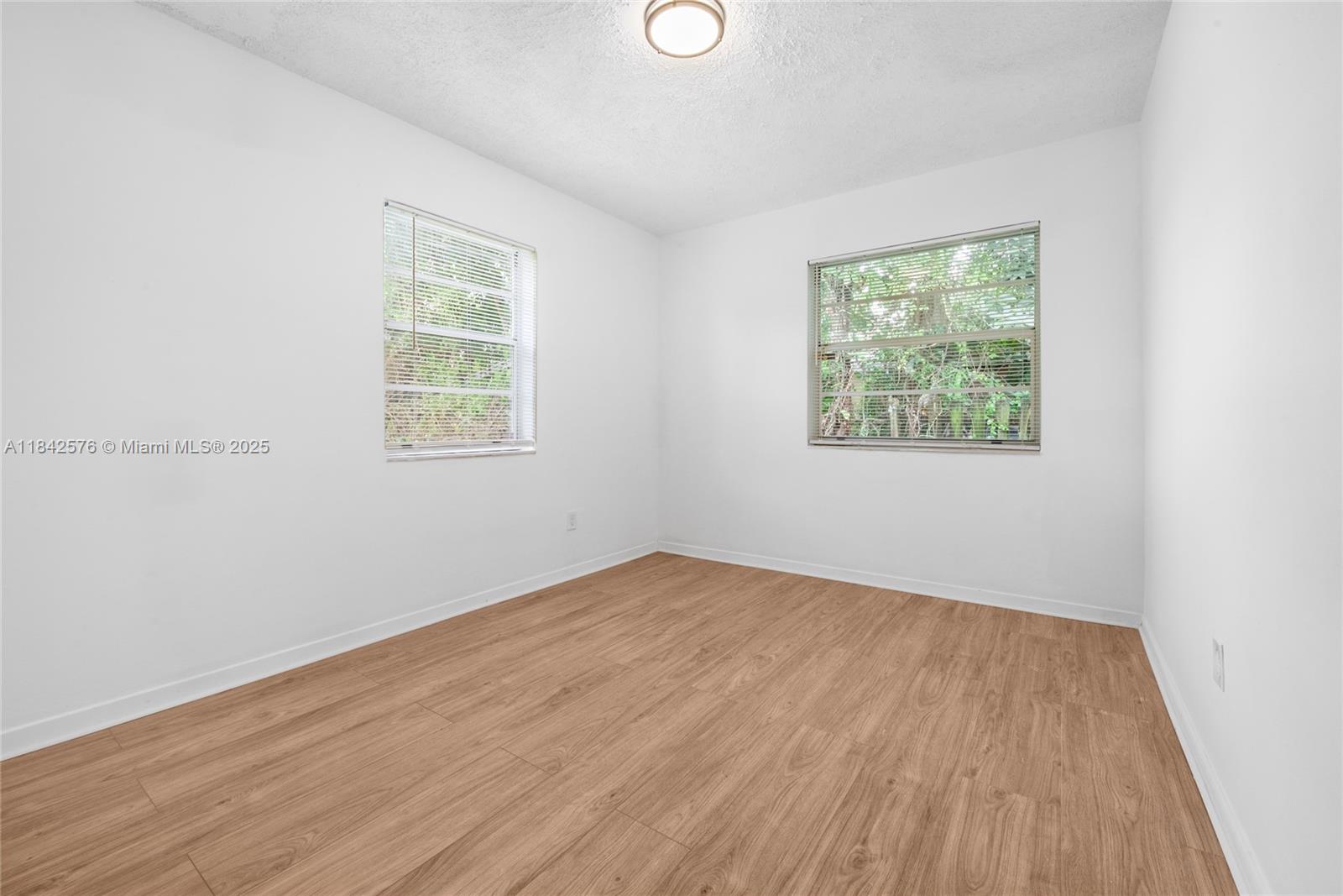 16921 Southwest 302nd Terrace Homestead, FL 33030 - Photo 11 of 14 an empty room with wooden floor and windows