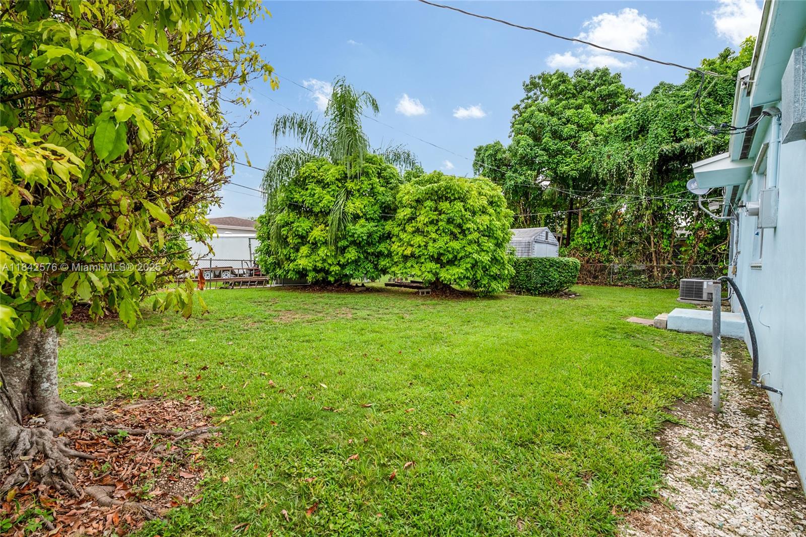 16921 Southwest 302nd Terrace Homestead, FL 33030 - Photo 14 of 14 a view of a yard with plants and a bench