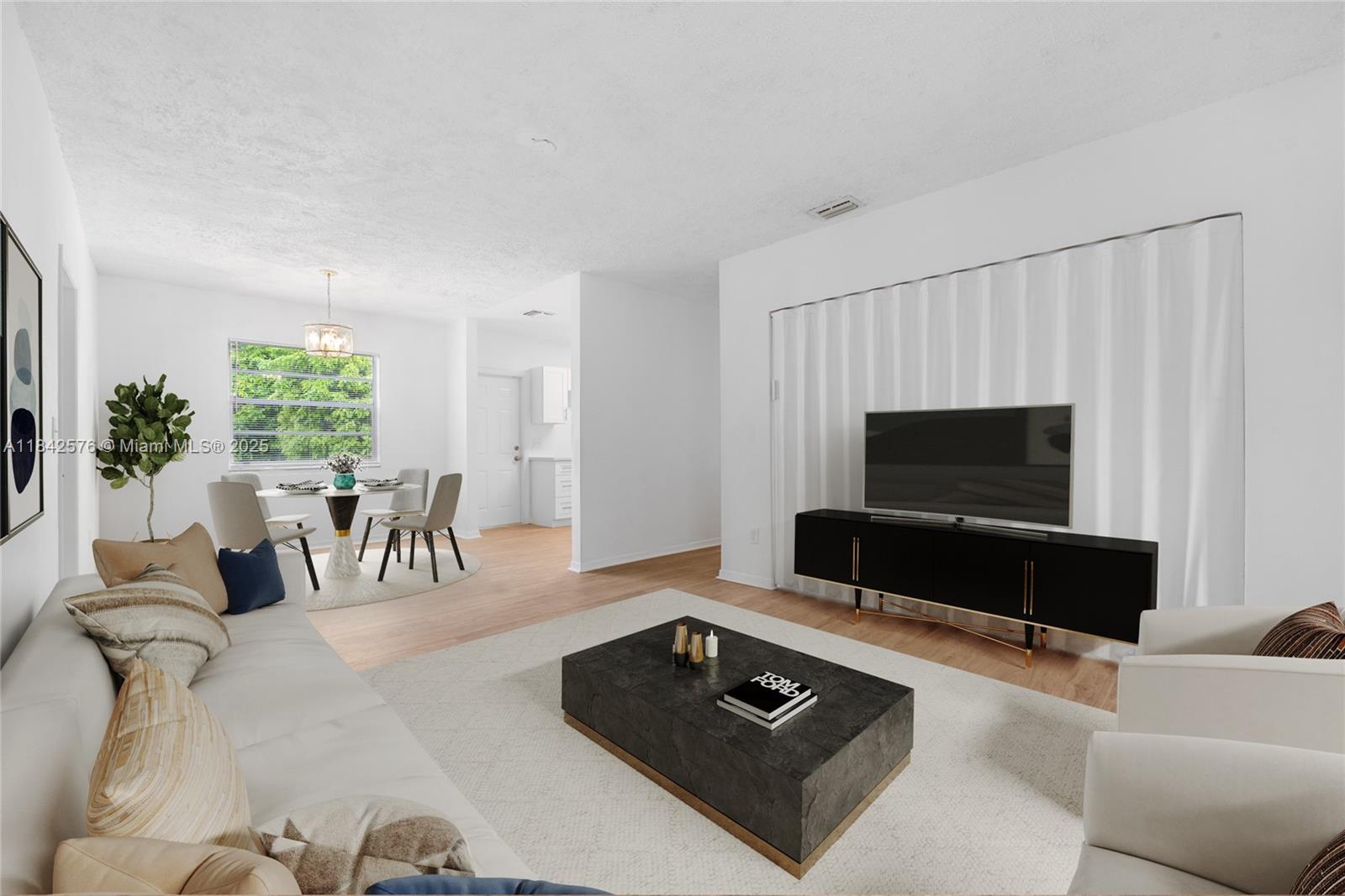 16921 Southwest 302nd Terrace Homestead, FL 33030 - Photo 4 of 14 a living room with furniture a flat screen tv and a large window