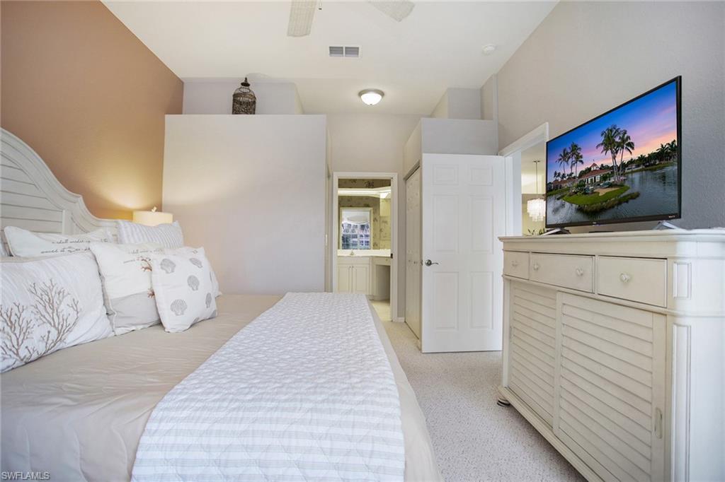 23821 Marbella Bay Road, Unit 202 Estero, FL 34135 - Photo 10 of 42 a bedroom with a bed and a flat screen tv