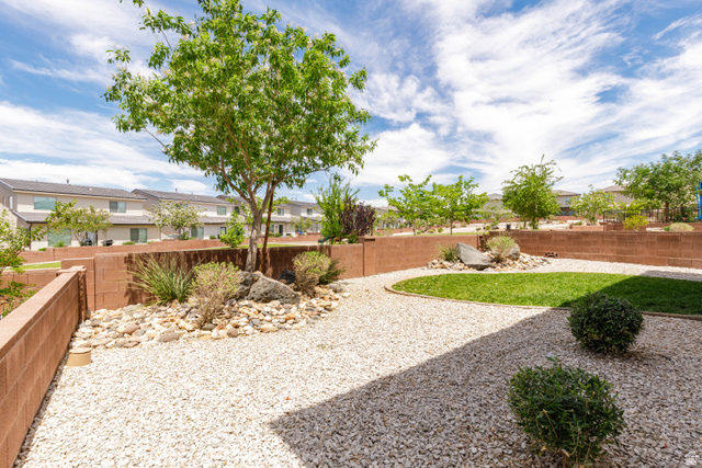 3157 Deseret Drive St. George, UT 84790 - Photo 23 of 24 Landscaped rear yard featuring a central green lawn area surrounded by white gravel
