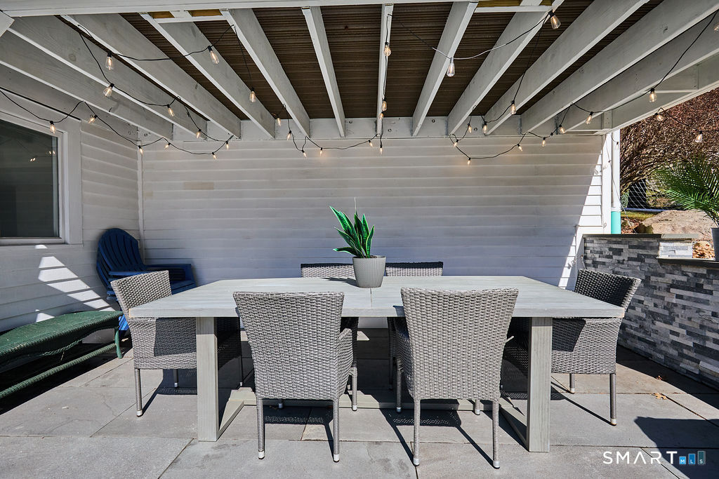 23 Harborview Road Westport, CT 06880 - Photo 32 of 35 a view of a patio with table and chairs with wooden floor and fence