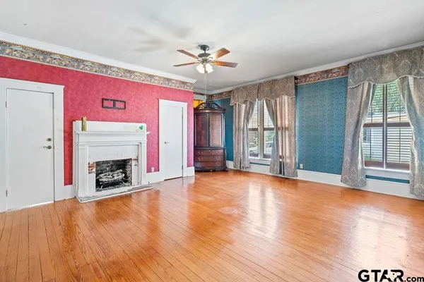 a view of an empty room with window and fire place