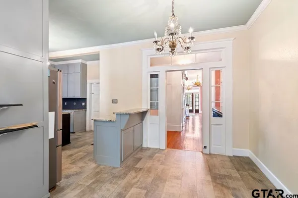a view of a hallway with wooden floor and chandelier