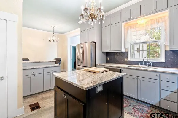 a kitchen with a sink refrigerator and cabinets