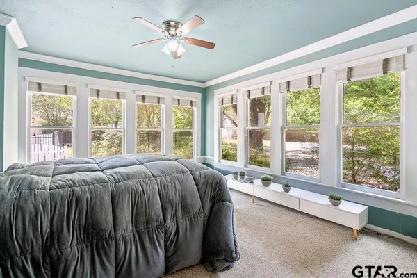 a bed sitting in front of a balcony next to a window