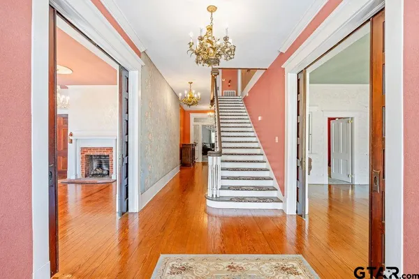 a view of a hallway with wooden floor and staircase