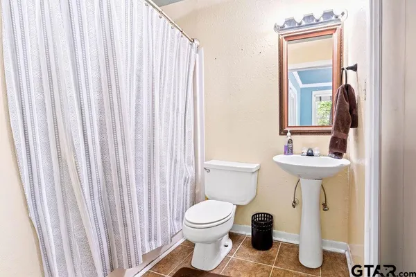 a bathroom with a toilet a sink and a mirror