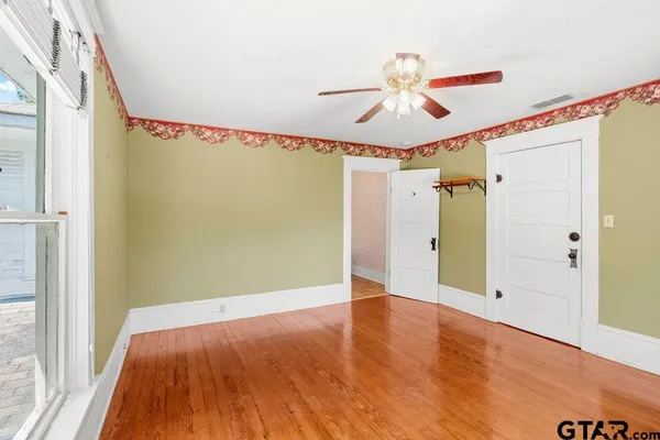 a view of a big room with wooden floor and windows