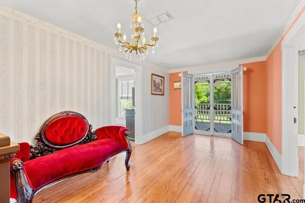 a view of an empty room with window and wooden floor
