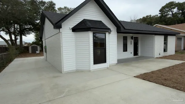 an empty room with wooden floor a ceiling fan and windows