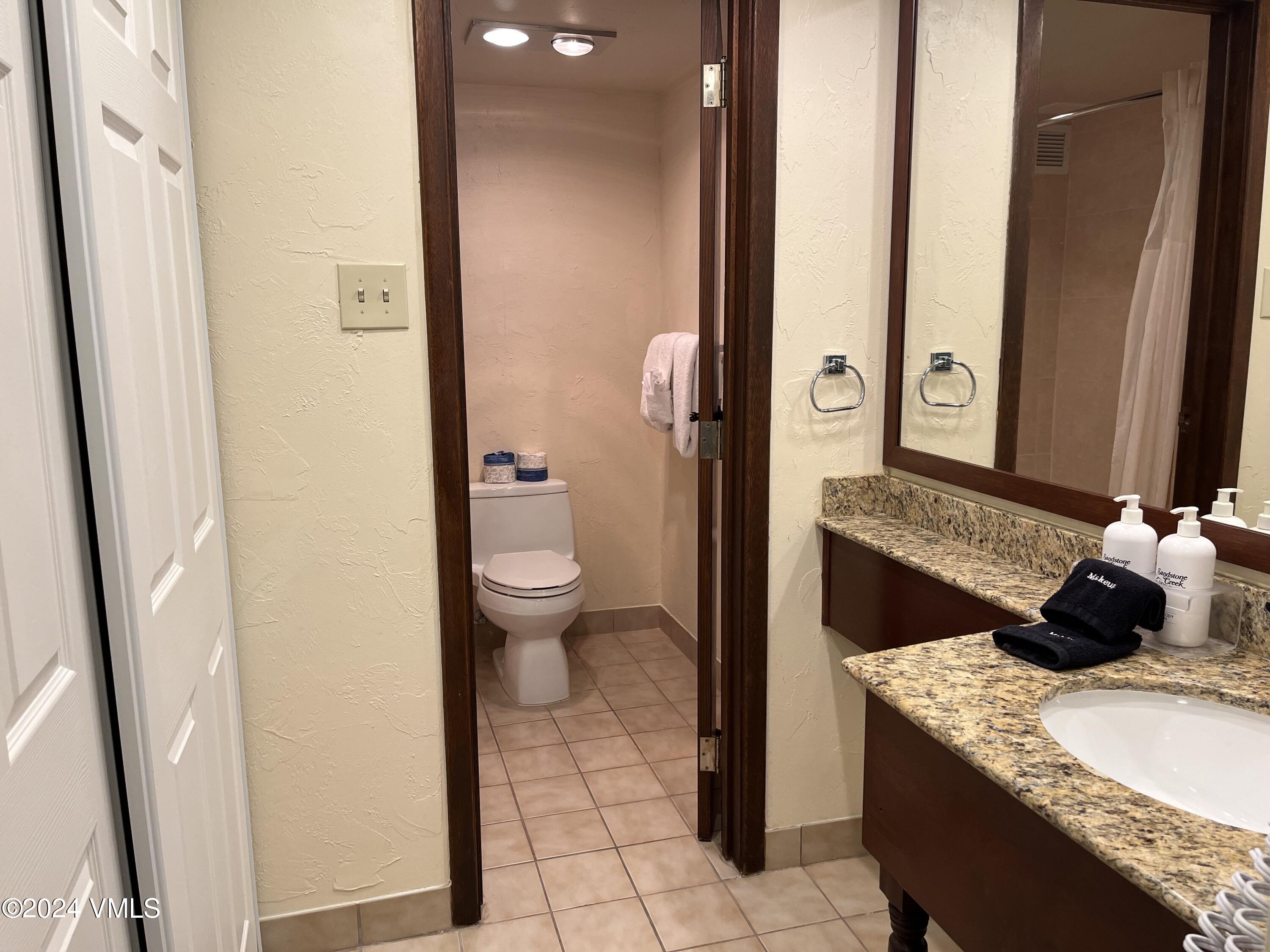 1020 Vail View Drive, Unit 210824 Vail, CO 81657 - Photo 6 of 19 a bathroom with a granite countertop sink and a mirror