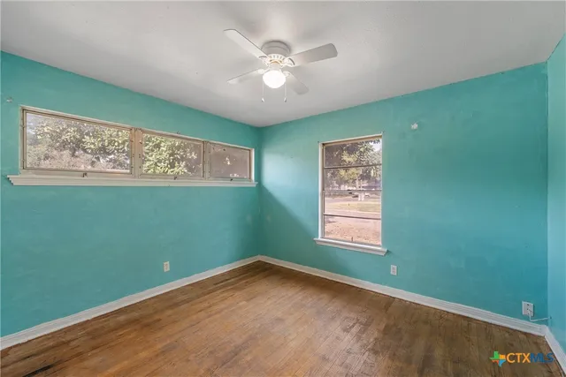 a view of an empty room with window and closet area
