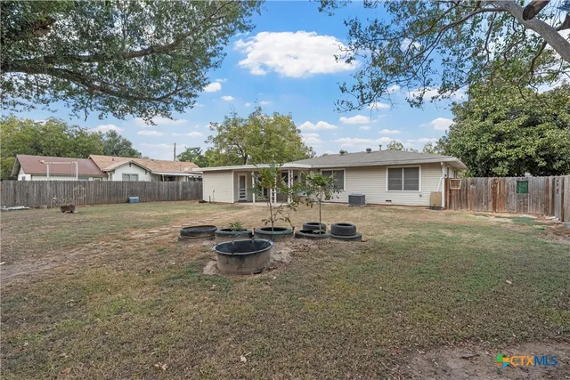 a view of a house with backyard and sitting area