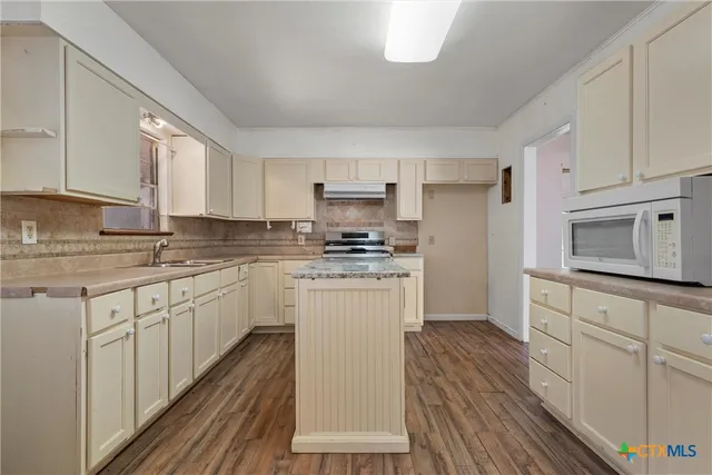 a kitchen with granite countertop white cabinets and white appliances