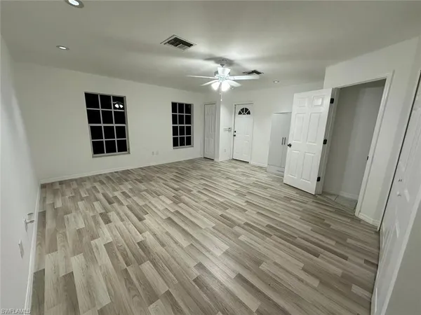 a view of an empty room with a window and fireplace