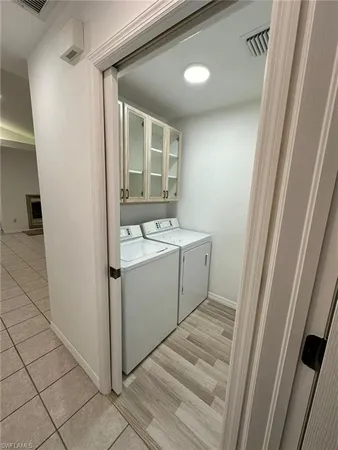 a utility room with a sink a cabinetry and a washer dryer