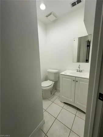 a spacious bathroom with a toilet sink and mirror