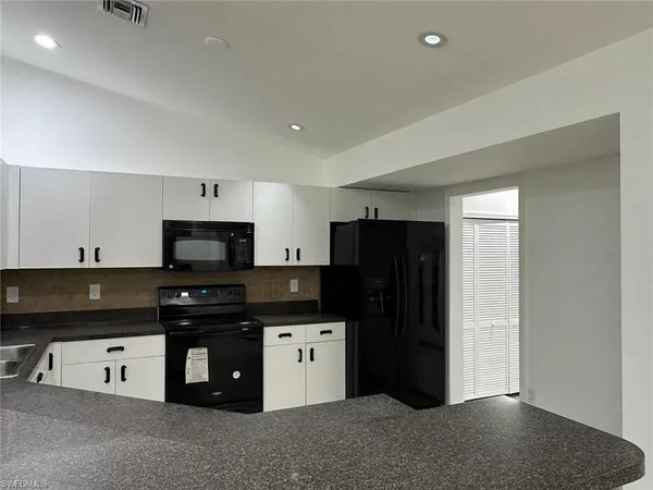 a kitchen with a sink a stove and cabinets
