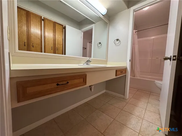 a spacious bathroom with a sink and a mirror