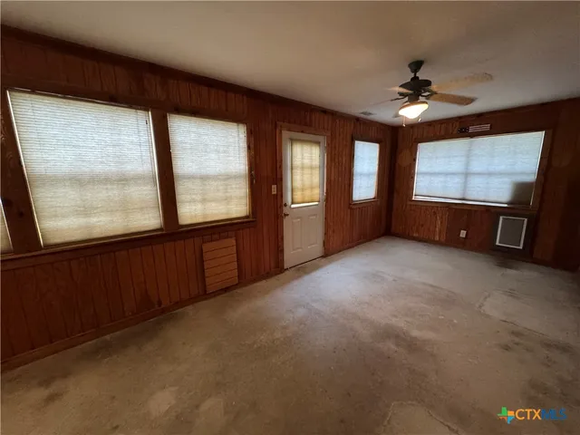 en empty room with windows and chandelier