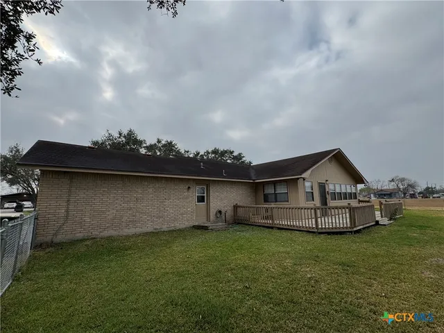 a view of a big house with a big yard and large trees