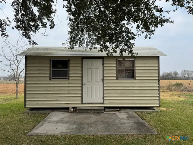 a view of a white house with a yard and garage