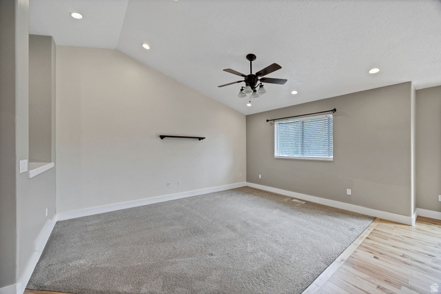 2912 South 1080th Street West Logan, UT 84321 - Photo 13 of 43 Spacious room featuring vaulted ceilings, recessed lighting, a ceiling fan with light kit, a window with blinds, and a combination of carpet and wood-finish flooring