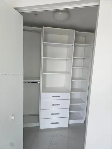 a living room with a flat screen tv and a refrigerator