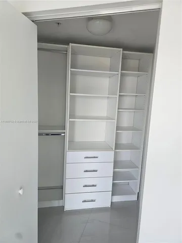 a living room with a flat screen tv and a refrigerator